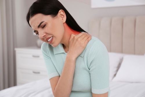 Female experiencing neck discomfort indoors