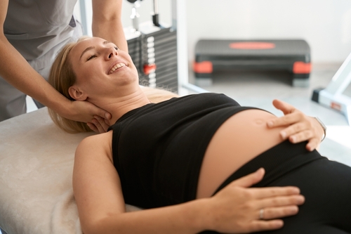 Pregnant woman receiving a chiropractic session for prenatal care.